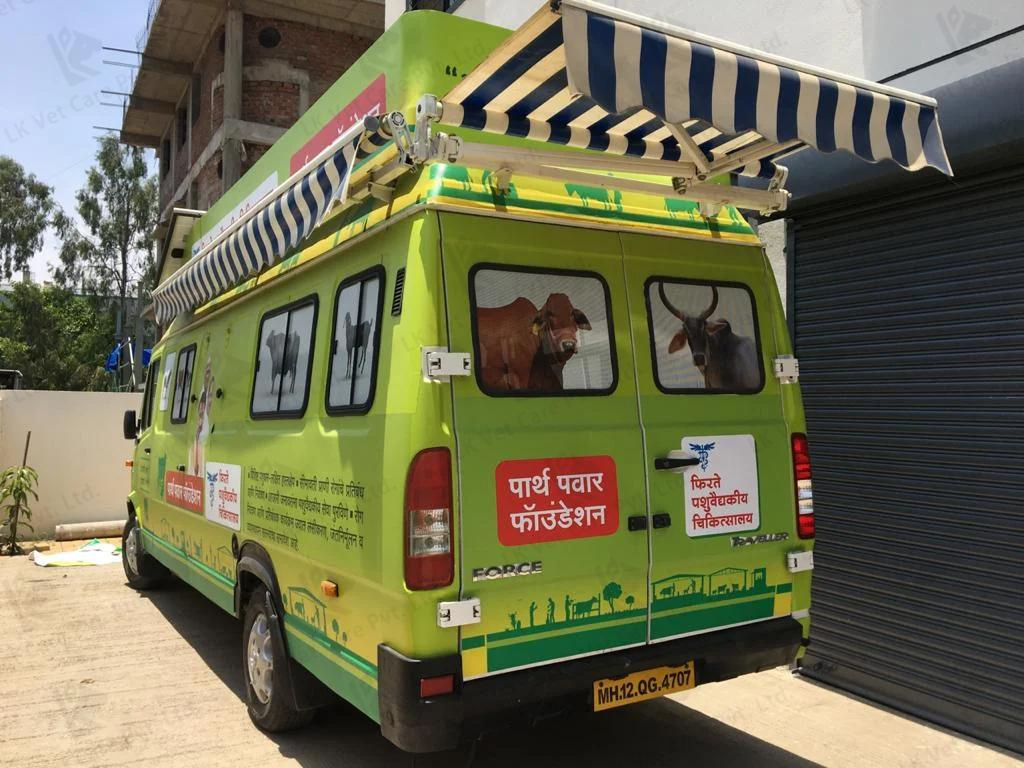 A green van with the Parshva Foundation logo, equipped as a mobile veterinary clinic. It features a large awning and medical equipment, ready to provide care to animals in need.